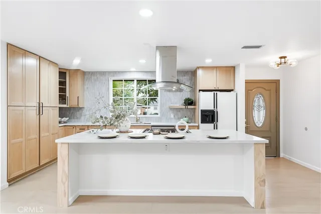 a kitchen with kitchen island sink stove and refrigerator