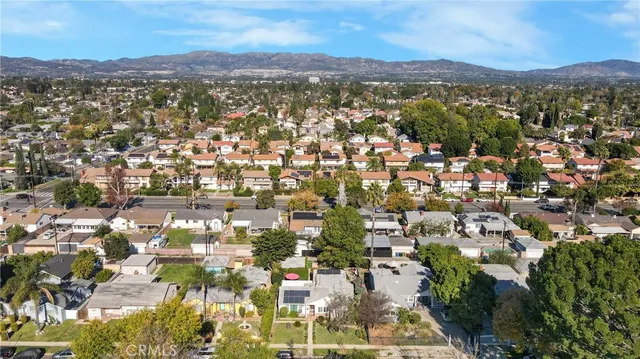 an aerial view of residential houses with outdoor space and trees