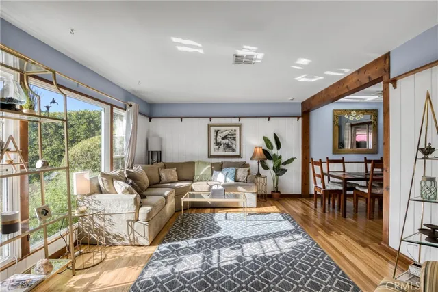 a living room with furniture wooden floor and a large window