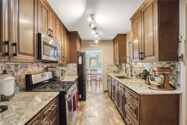 a kitchen with stainless steel appliances granite countertop a sink stove and refrigerator