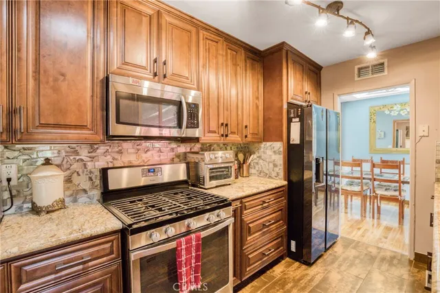 a kitchen with stainless steel appliances granite countertop a stove a sink and a microwave