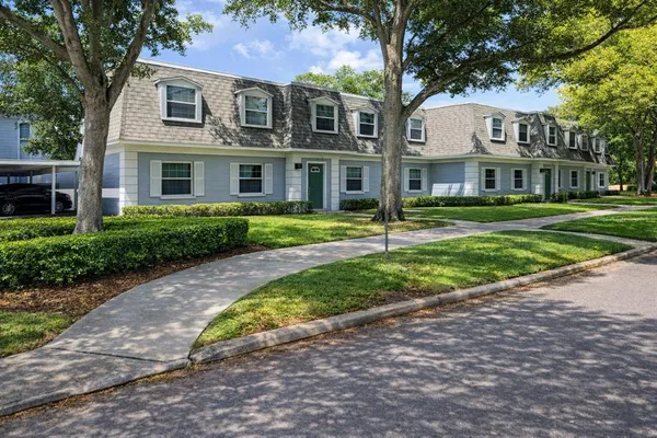 a front view of a residential houses with yard and green space