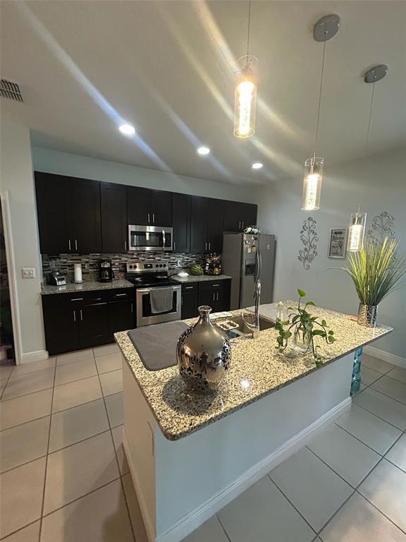 810 Cardinal Way Kissimmee, FL 34759 - Photo 5 of 12 a kitchen with kitchen island stainless steel appliances a sink counter top space and cabinets