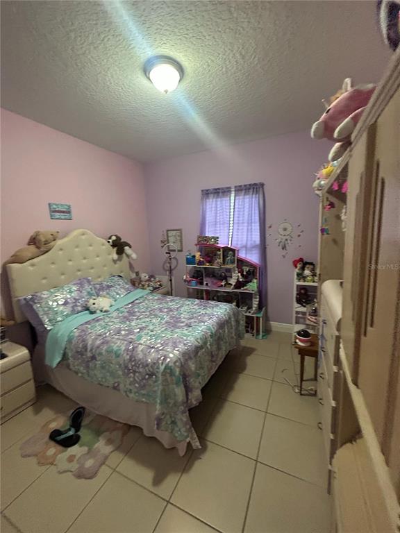 810 Cardinal Way Kissimmee, FL 34759 - Photo 9 of 12 a bedroom with a bed and a chandelier