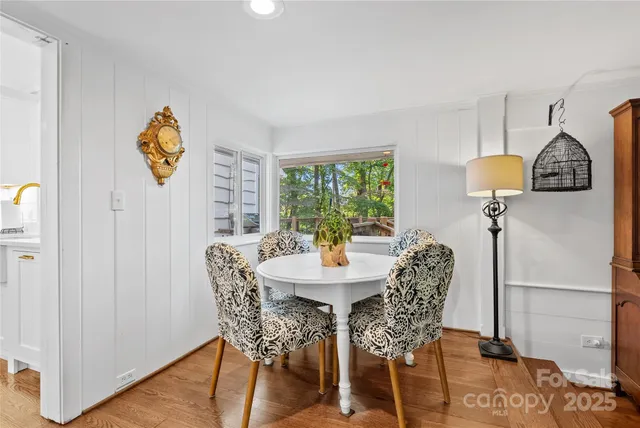 a dining room with furniture window and wooden floor