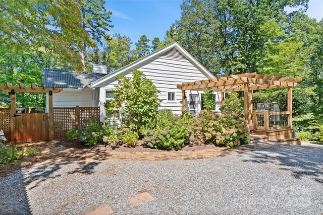 a view of a house with a yard and potted plants