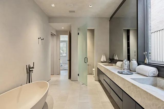 a bathroom with a double vanity sink mirror double and bathtub