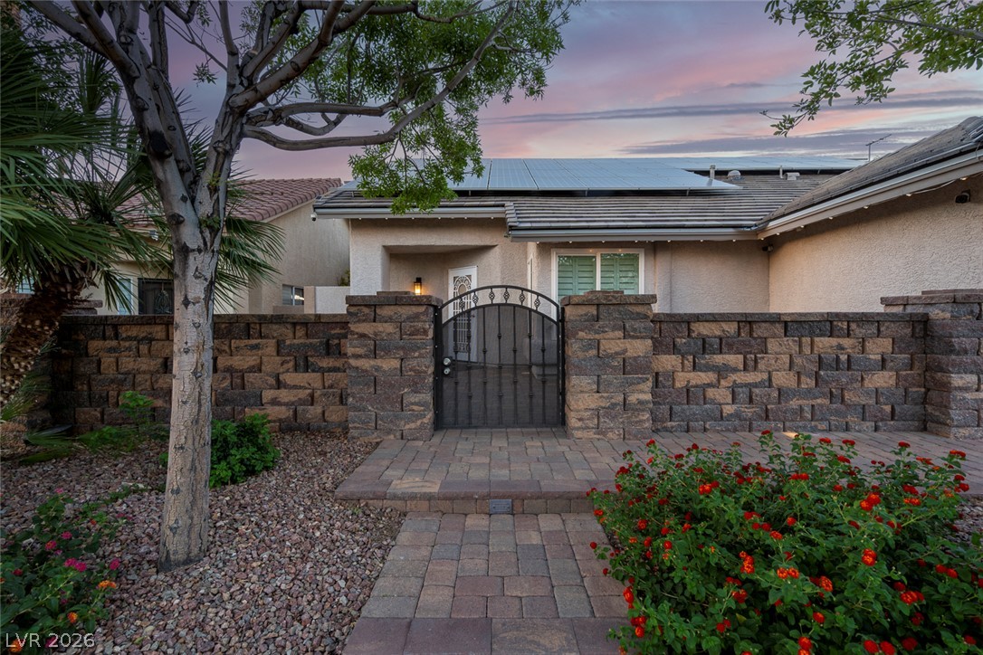 818 Manor Shores Road Henderson, NV 89002 - Photo 3 of 35 Secure entry via a charming wrought iron gate and stone block wall, enhancing this inviting curb appeal.