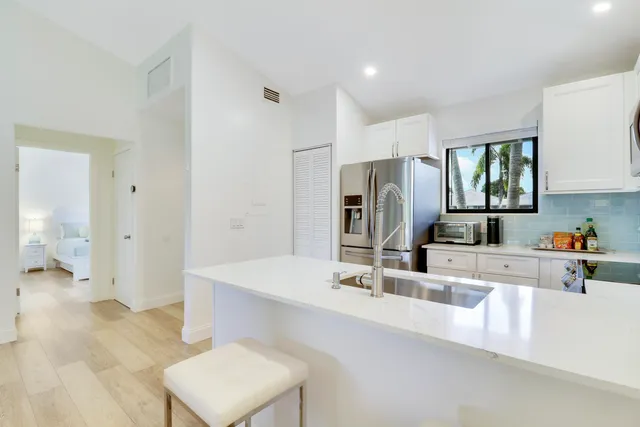 a kitchen with kitchen island a sink stove and a refrigerator