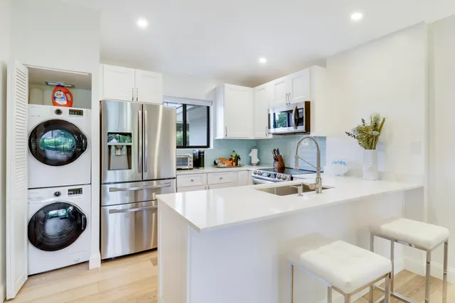 a kitchen with stainless steel appliances a sink and a refrigerator