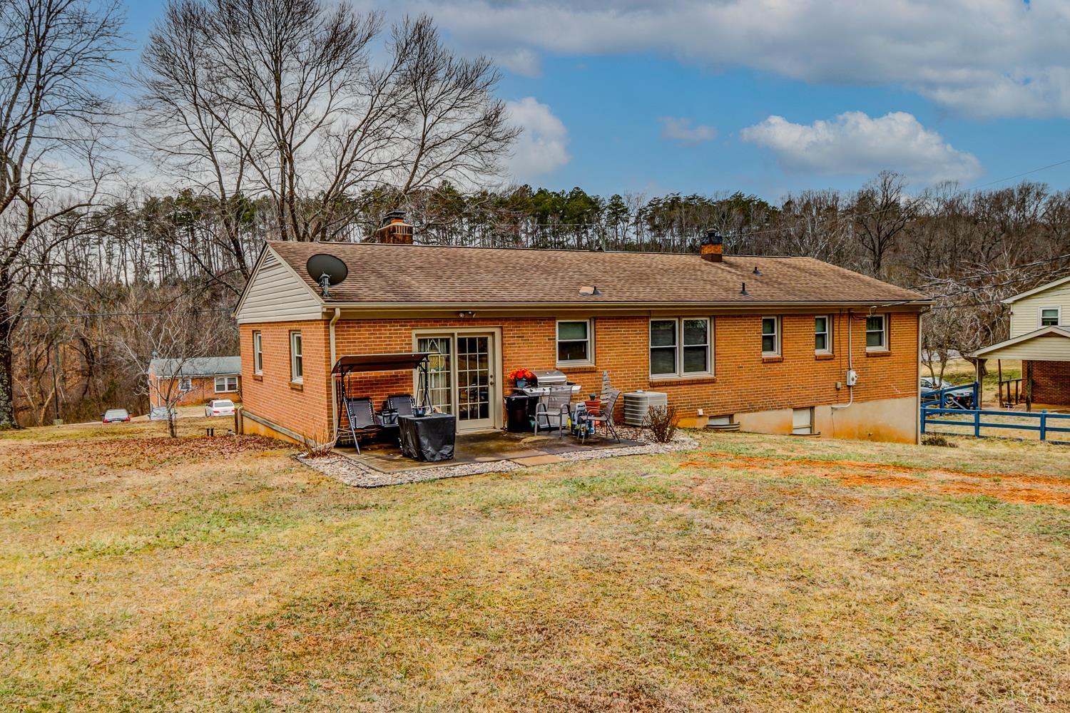 7143 Gladys Road Altavista, VA 24517 - Photo 44 of 48 a view of a big house with table and chairs under an umbrella