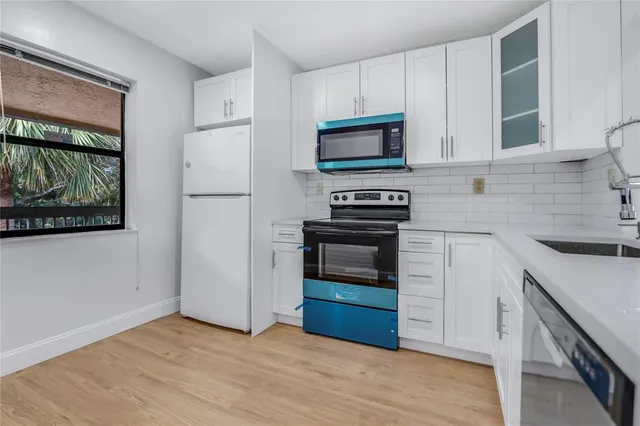 a kitchen with stainless steel appliances a stove microwave and sink