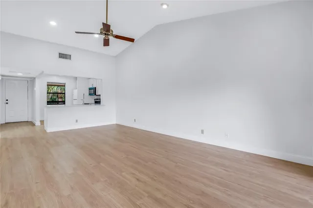 a view of a room with a dishwasher and wooden floor