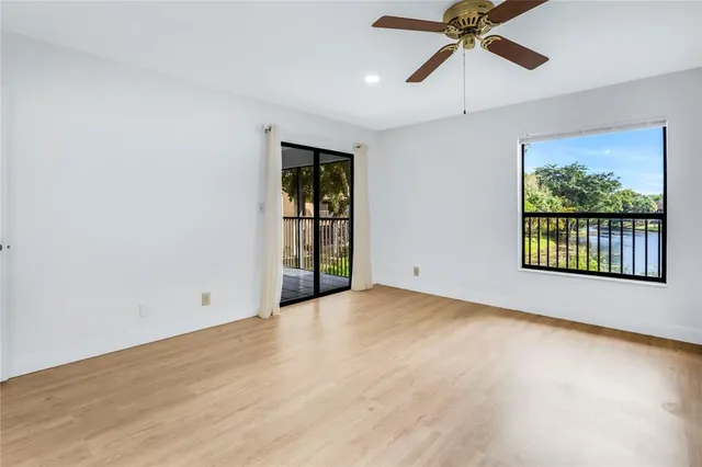 an empty room with windows and fan