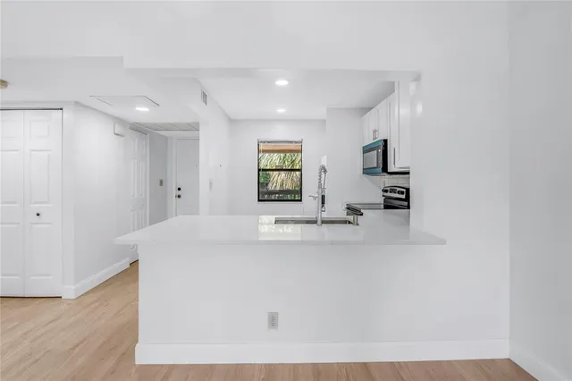 a view of kitchen with windows and dual sinks