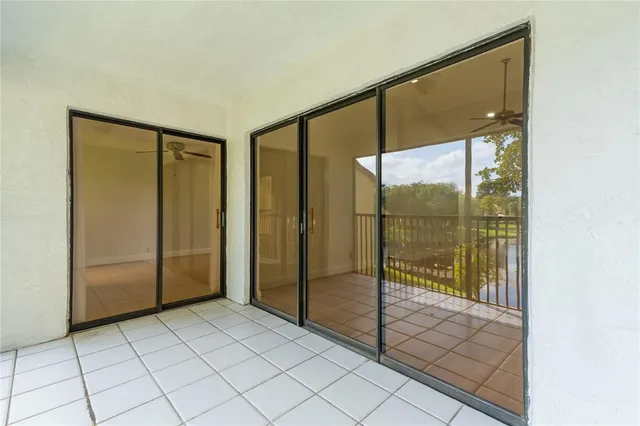 a view of a hallway with wooden floor and a bathroom