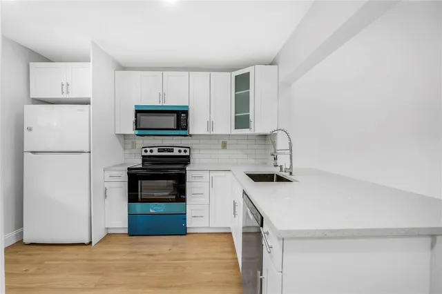 a kitchen with a refrigerator and a stove top oven