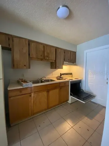 a kitchen with sink a microwave and cabinets