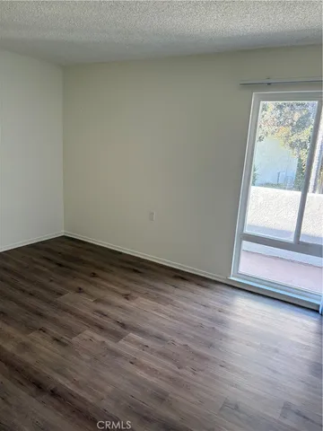 an empty room with wooden floor and a window