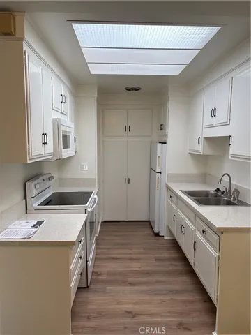 a kitchen with granite countertop a sink stove and refrigerator