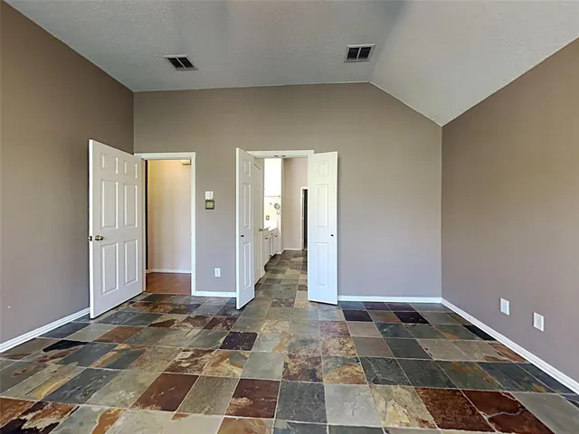 a view of a livingroom with wooden floor and a bathroom