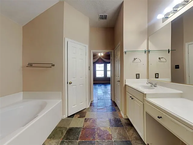 a spacious bathroom with a bathtub and a double vanity sink