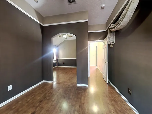 a view of empty room with wooden floor
