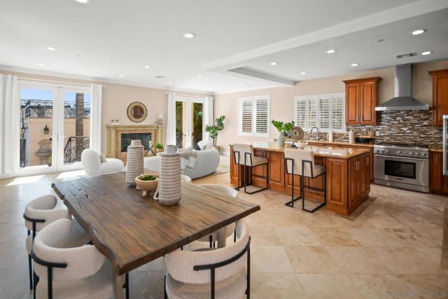 a dining room with stainless steel appliances granite countertop a table and chairs