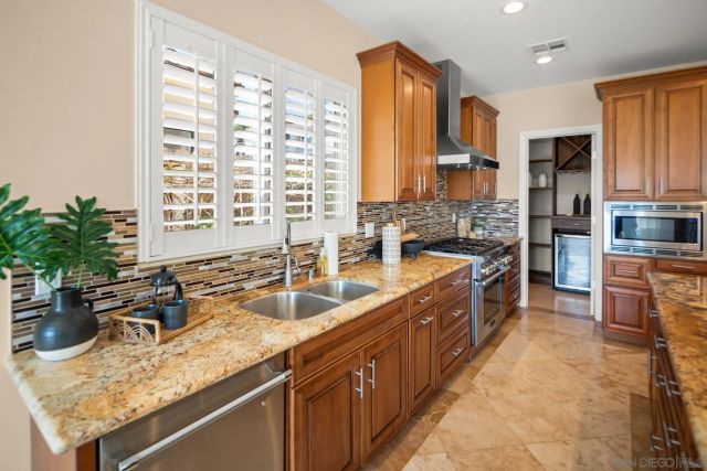 a large kitchen with kitchen island granite countertop a sink and a stove