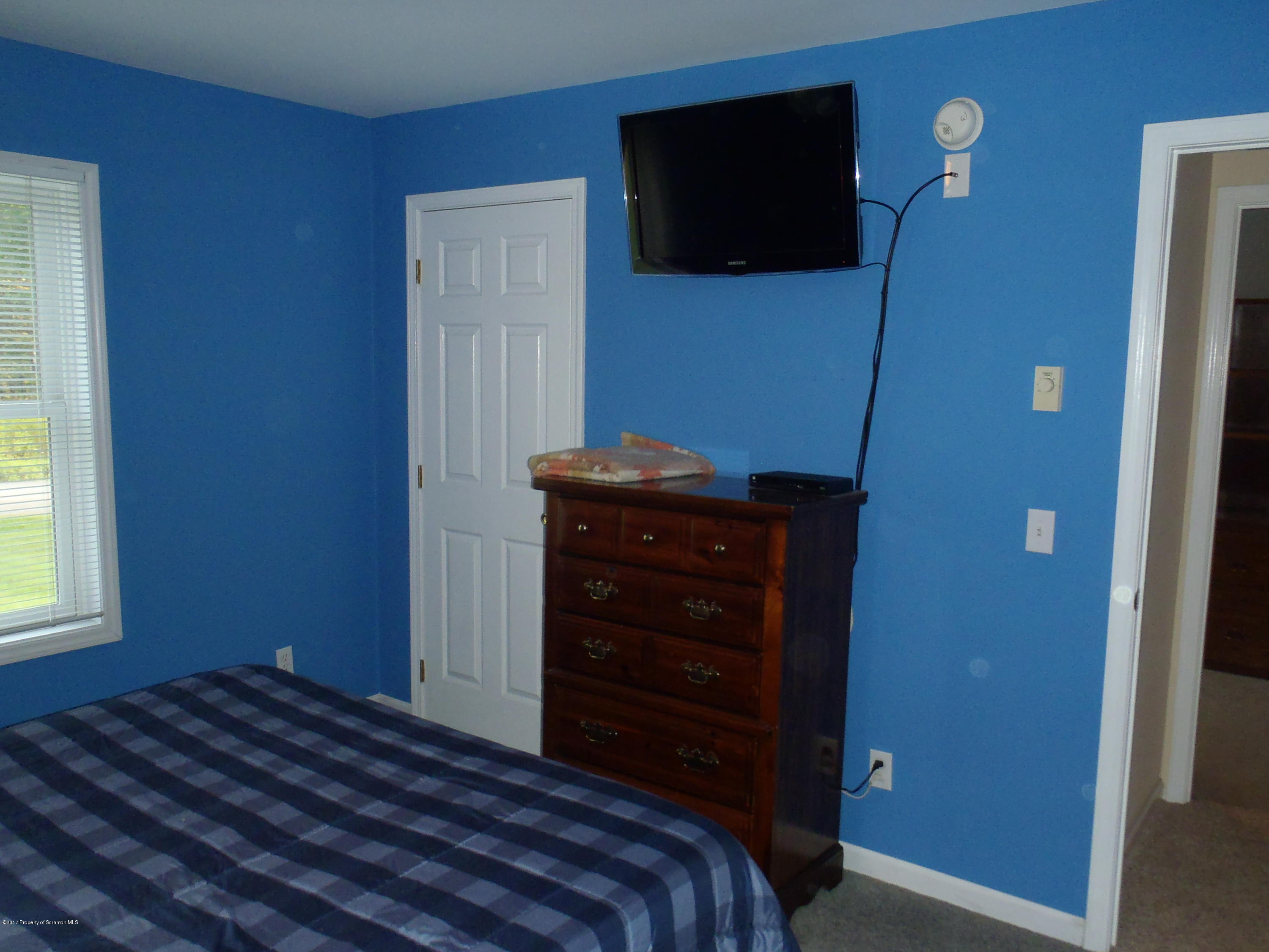 5441 Cottrell Road Union Dale, PA 18470 - Photo 14 of 19 a bedroom with a bed and a flat tv screen on dresser