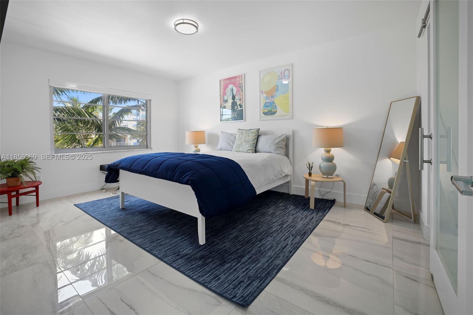 1450 Lincoln Road, Unit 403 Miami Beach, FL 33139 - Photo 20 of 29 a spacious bedroom with a bed a couch and a window