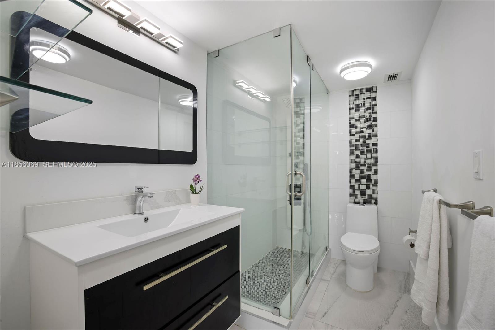 1450 Lincoln Road, Unit 403 Miami Beach, FL 33139 - Photo 21 of 29 a bathroom with a sink a toilet a shower and a mirror