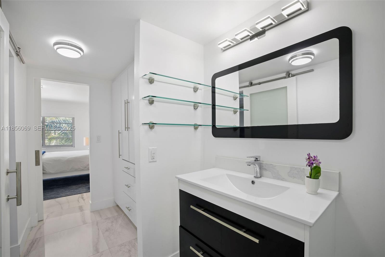 1450 Lincoln Road, Unit 403 Miami Beach, FL 33139 - Photo 22 of 29 a en suite bathroom with a sink and a mirror