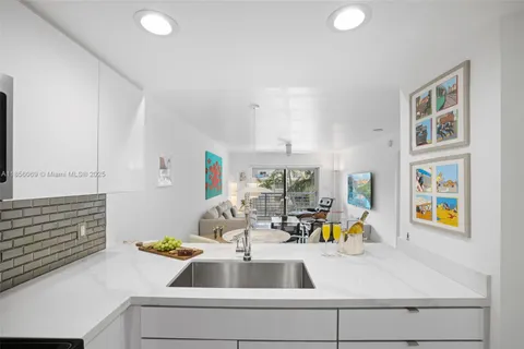 a kitchen with stainless steel appliances granite countertop a stove top oven a sink dishwasher a dining table and chairs with wooden floor