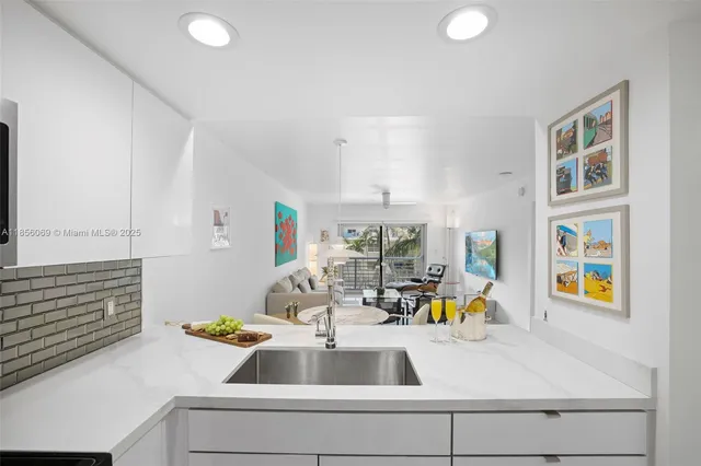 a kitchen with stainless steel appliances granite countertop a stove top oven a sink dishwasher a dining table and chairs with wooden floor