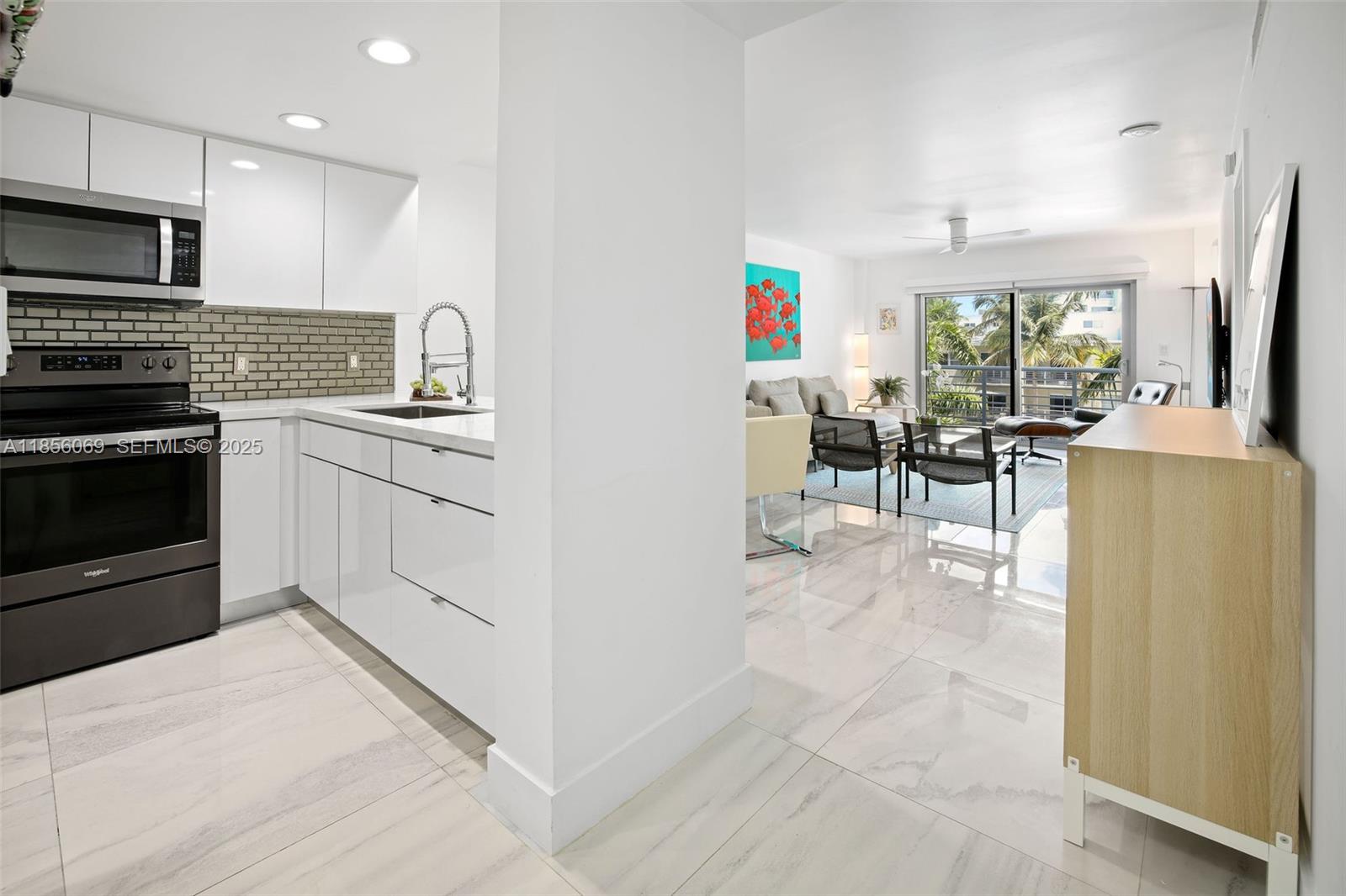 1450 Lincoln Road, Unit 403 Miami Beach, FL 33139 - Photo 7 of 29 a kitchen with stainless steel appliances granite countertop a stove top oven a sink dishwasher a dining table and chairs with wooden floor