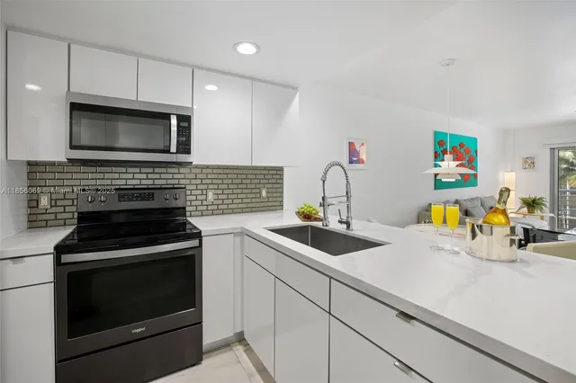 a kitchen with stainless steel appliances kitchen island granite countertop a sink and a couch