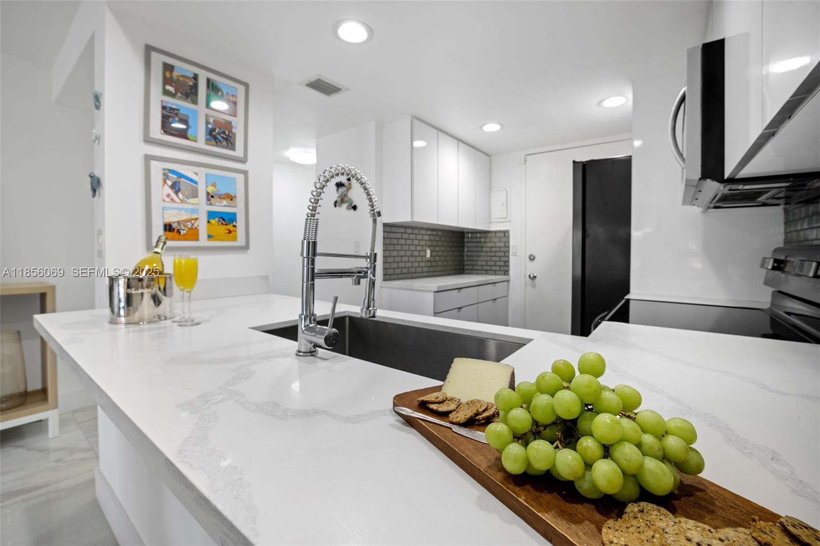 1450 Lincoln Road, Unit 403 Miami Beach, FL 33139 - Photo 10 of 29 a kitchen with stainless steel appliances kitchen island granite countertop a sink and a couch