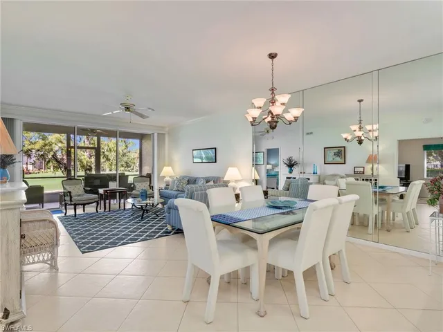 a dining room with furniture a chandelier and window