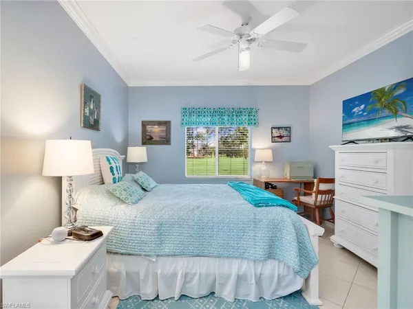 a bedroom with a bed and a flat tv screen on dresser