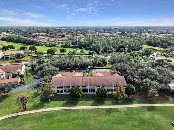 an aerial view of a residential houses with outdoor space and trees