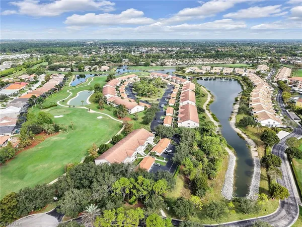 an aerial view of a resort with swimming pool tennis courts and ocean view