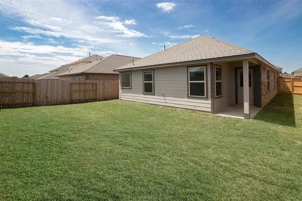 a view of a house with a yard and fence