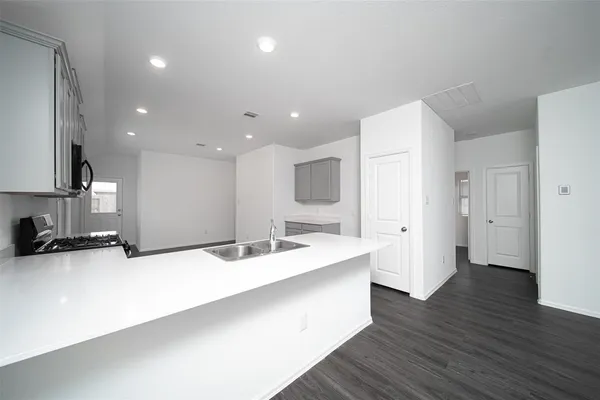 a large white kitchen with a sink and dishwasher
