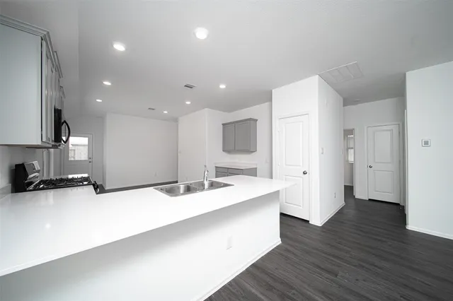 a large white kitchen with a sink and dishwasher