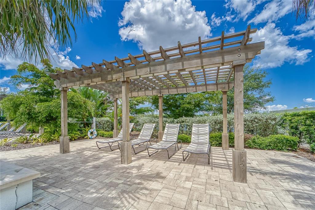 5534 Silver Sun Drive Apollo Beach, FL 33572 - Photo 69 of 76 a view of a patio with a table chairs and a floor to ceiling window