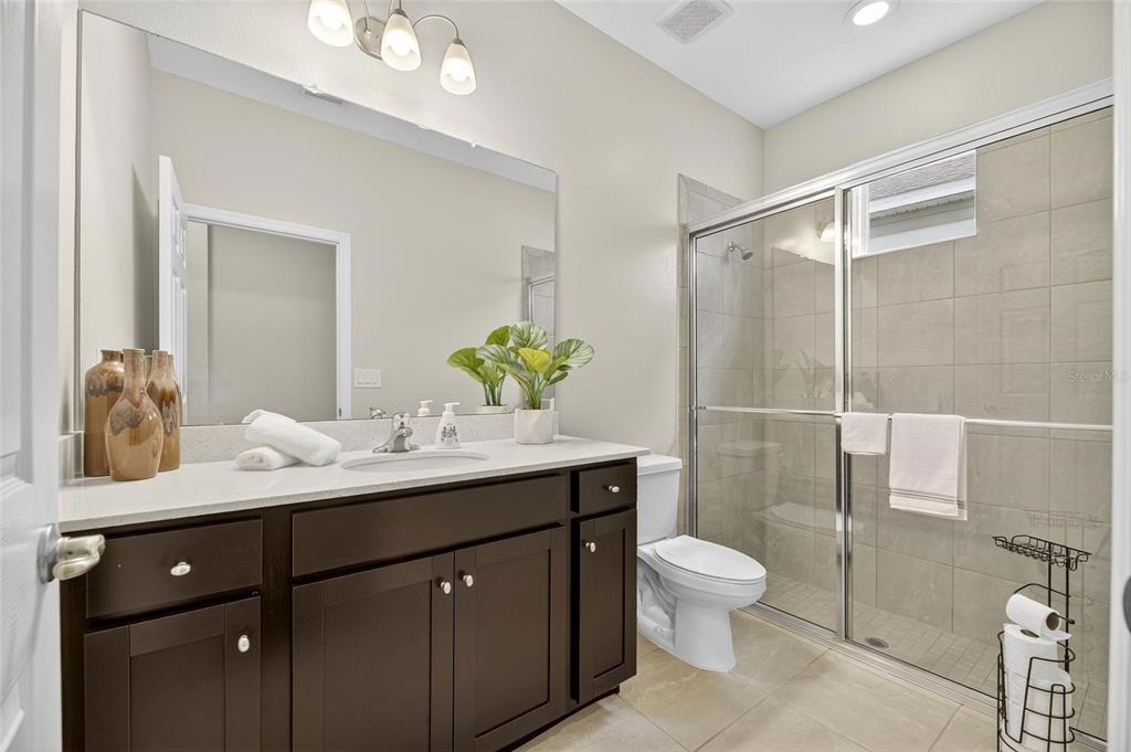 5534 Silver Sun Drive Apollo Beach, FL 33572 - Photo 10 of 76 a bathroom with a granite countertop sink toilet a mirror and shower