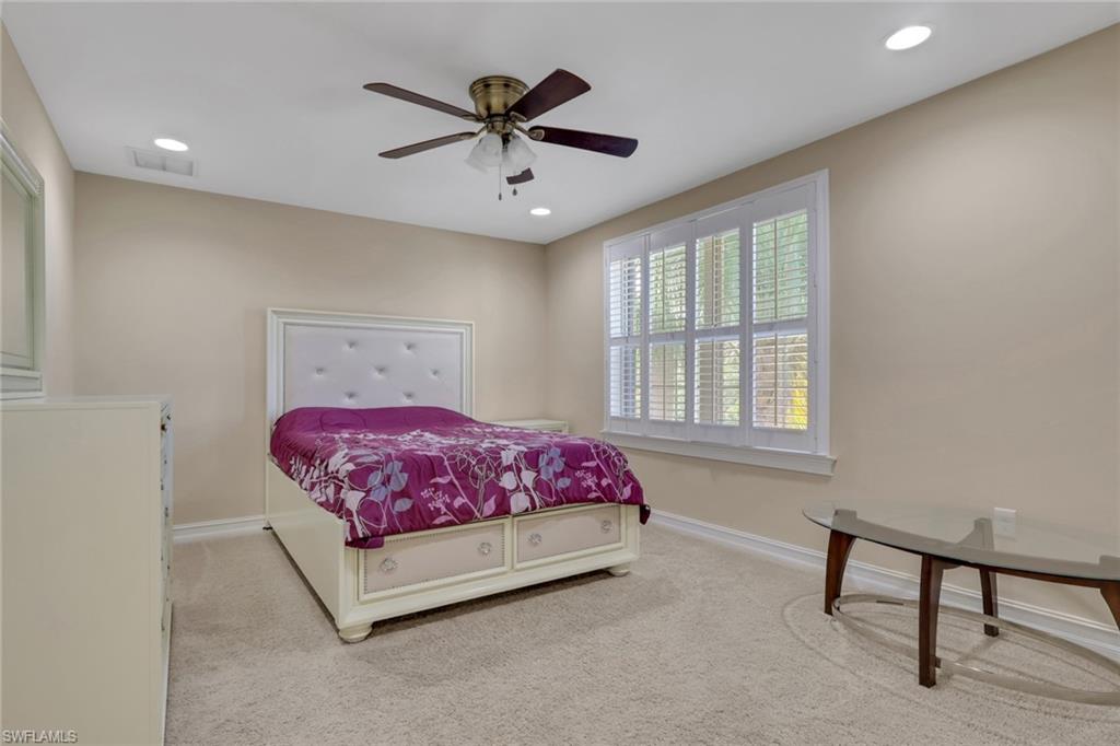 16309 Aberdeen Way Naples, FL 34110 - Photo 19 of 34 a bedroom with a bed a chandelier and a window