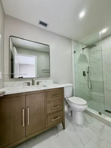 a bathroom with a double vanity sink toilet and shower