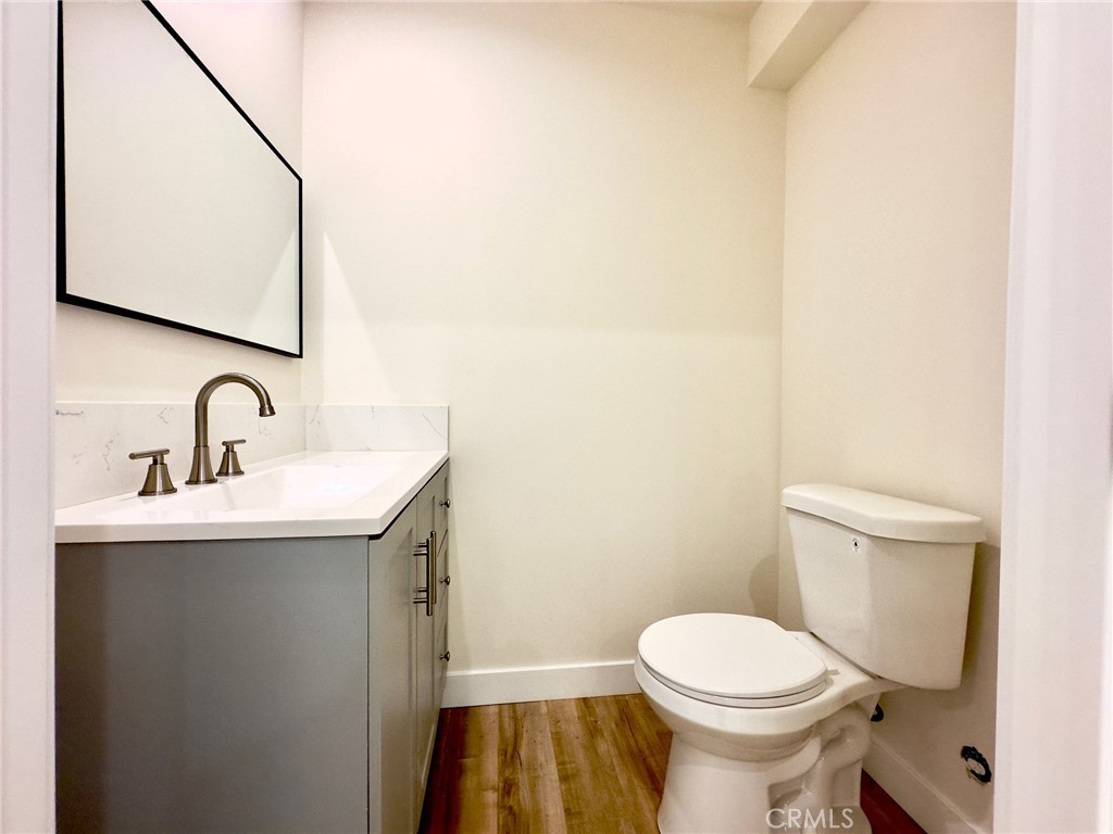 15952 Cohasset Street Van Nuys, CA 91406 - Photo 4 of 11 a bathroom with a toilet a sink and mirror
